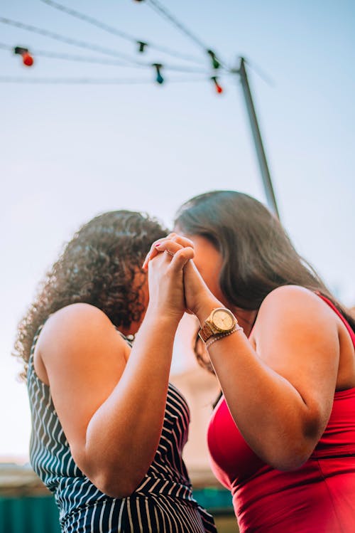 Two women are holding hands and smiling at each other