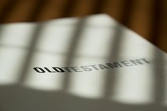 Close-up of an Old Testament page with sunlight streaming through blinds.