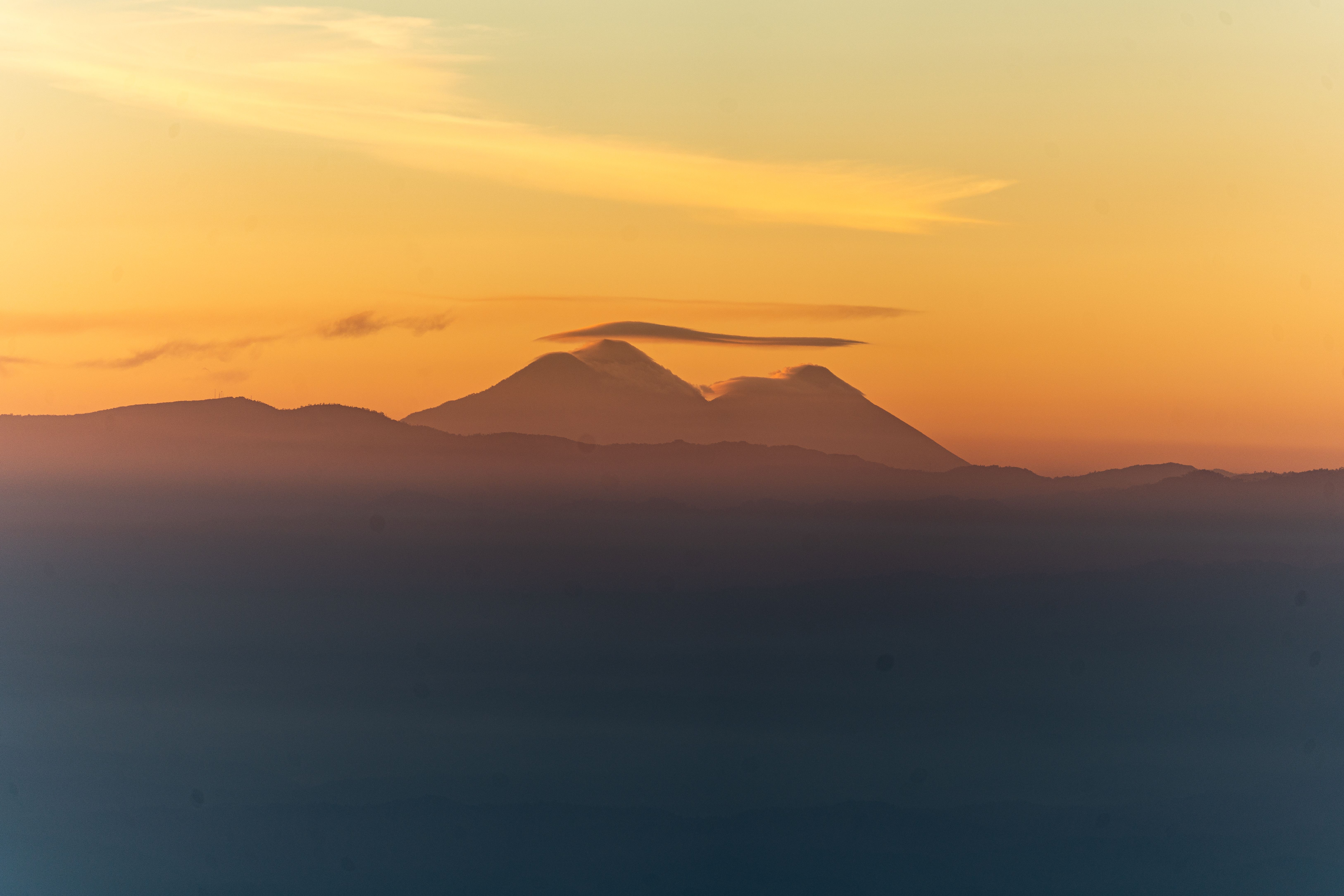 Golden sunset over silhouette mountains in Chiantla, Guatemala, capturing serene and breathtaking landscape.