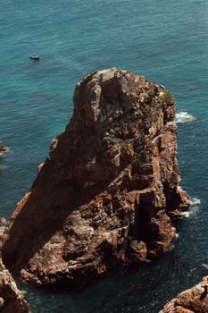 Explore the stunning rocky shores of Colares, Lisbon, with vibrant blue ocean views.