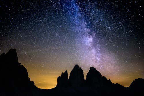 Силуэтная фотография Скалистых гор под звездным небом