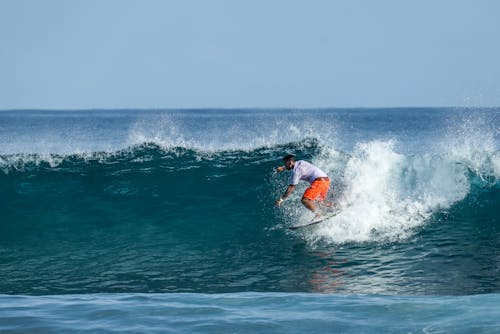 Man Surfing Wave On Surf Board In Ocean