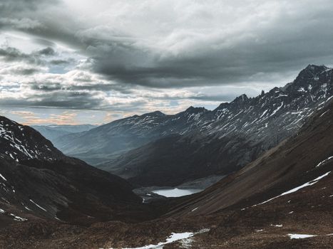 Panoramic view of rugged mountains and cloudy sky in the Magallanes region of Chile. Perfect for nature lovers.