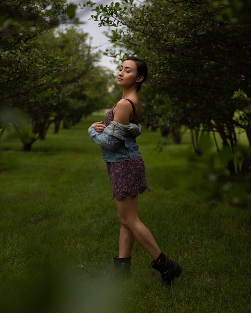 Donna Che Indossa Un Abito Floreale E Una Giacca Di Jeans In Posa Per Una Foto