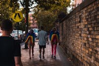 人们在城市街道上戴着彩虹翅膀游行