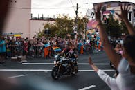 在骄傲游行的欢乐场景中，兴奋的参与者骑着摩托车，挥舞着旗帜