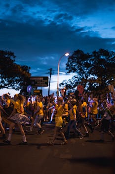 夜晚的街头游行充满活力，舞者与灯火通明的人群热闹非凡