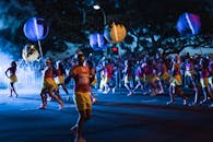 夜晚，舞者提着灯笼在街头举行节日游行，展示着充满活力的庆祝活动