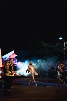 在夜间街头节日上，游行表演者穿着充满活力的服装，跳着令人眼花缭乱的舞蹈