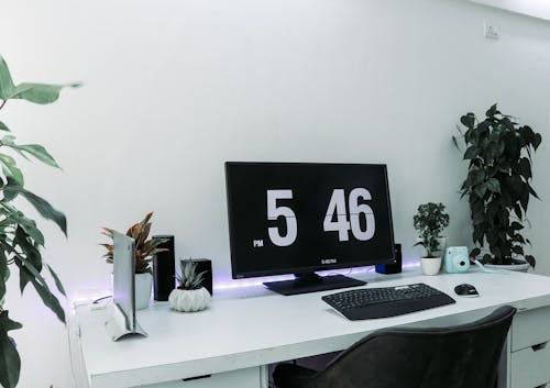 흰색 테이블 위에 검은 색 평면 스크린 컴퓨터 모니터와 검은 색 컴퓨터 키보드