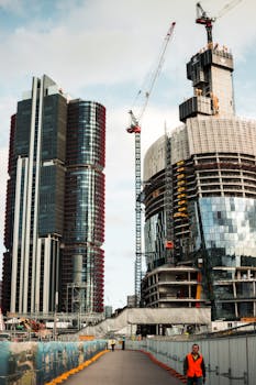 城市景观充满活力，热闹的环境中可见在建的摩天大楼和起重机