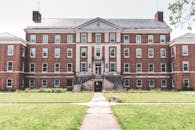 这是一座历史悠久的砖砌建筑，融合了古典元素，拥有对称的立面和广阔的草坪