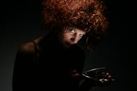 在低调的灯光下，捕捉到了一位卷发女性的戏剧性图像