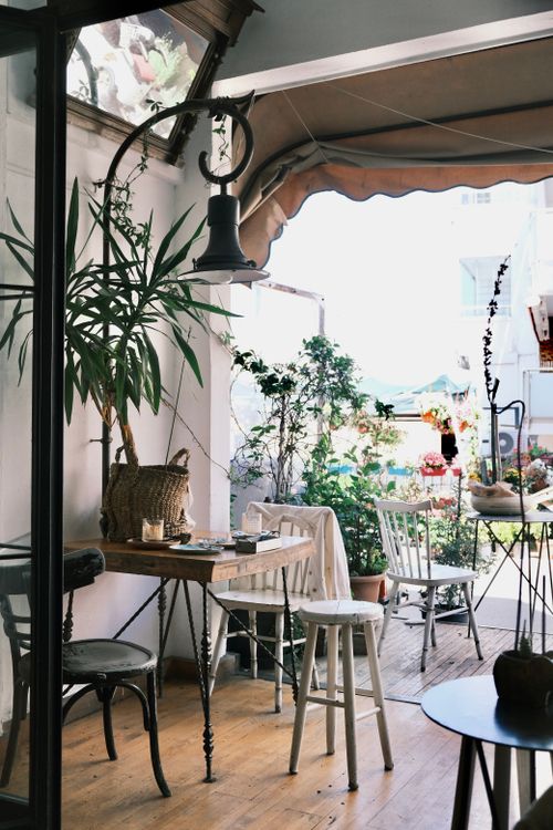 Free Cozy garden patio with tables and chairs surrounded by lush plants in Kınalıada, İstanbul. Stock Photo