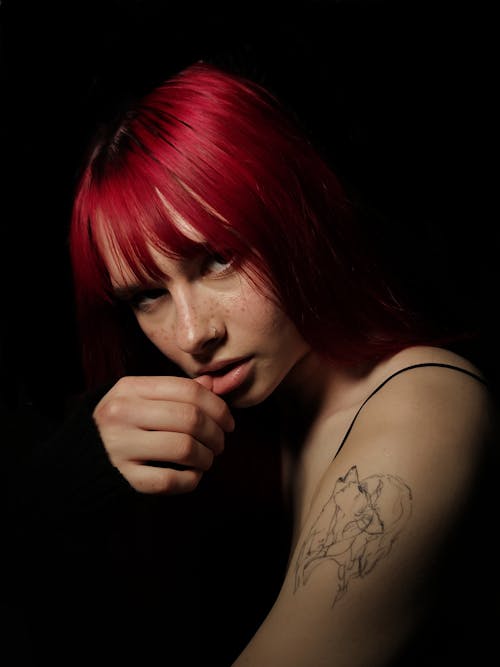 A woman with red hair and tattoos on her arm