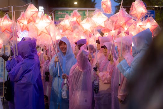 A vibrant lantern parade in Seoul featuring people in raincoats holding glowing star lanterns.
