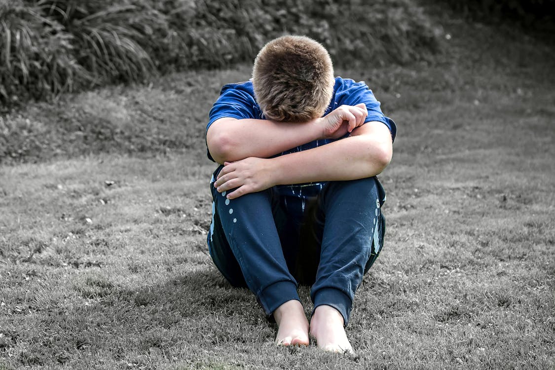 Rear View of a boy Sitting on Grassland