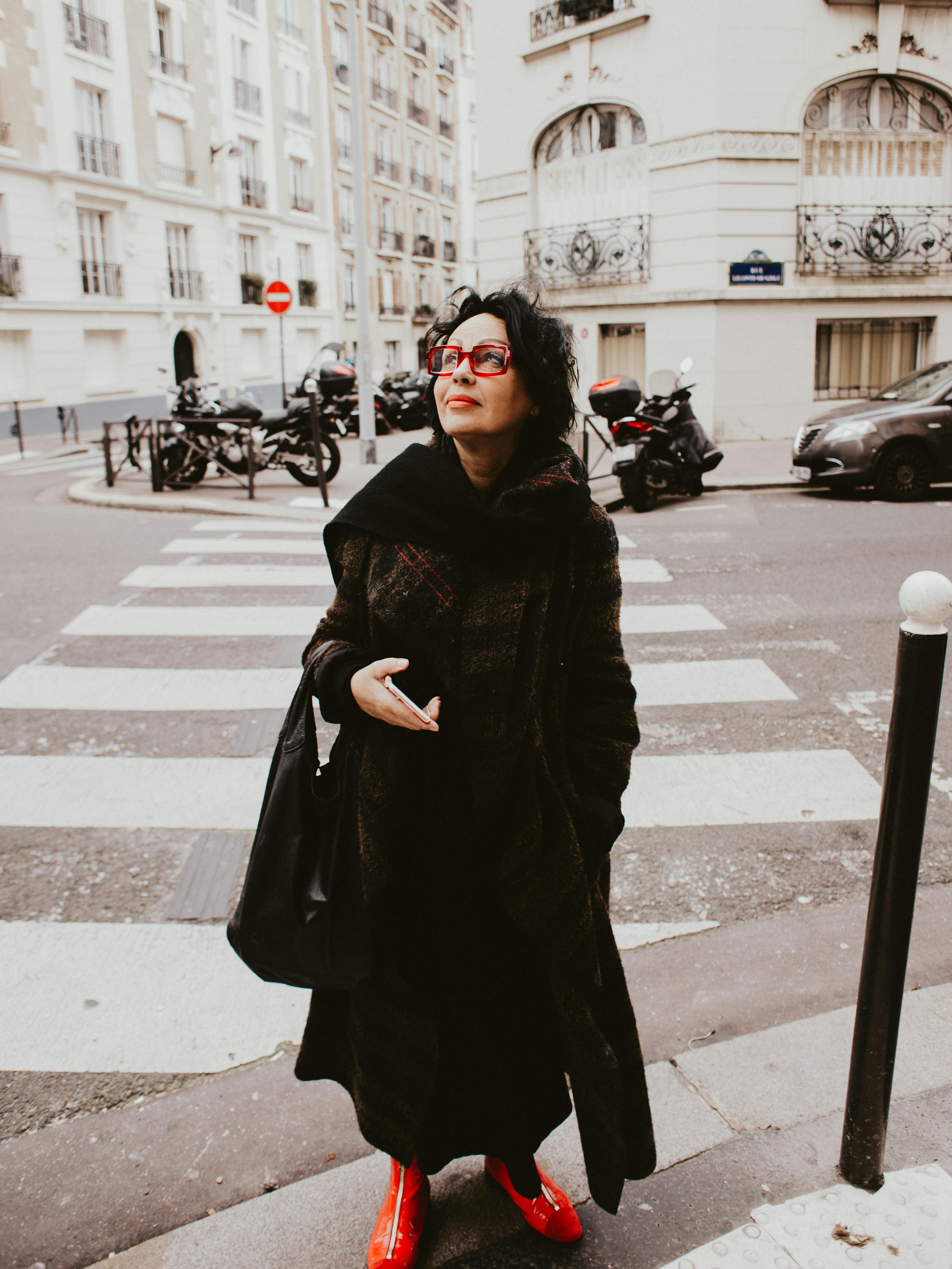 Woman wearing black coat and staring at a building | Photo: Pexels