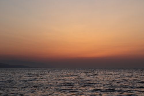 Free Captivating view of the ocean at sunset with a golden sky, perfect for relaxation themes. Stock Photo