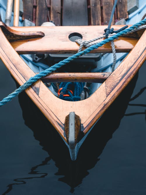 免費 綁在水面上的棕色木船上的繩索 圖庫相片