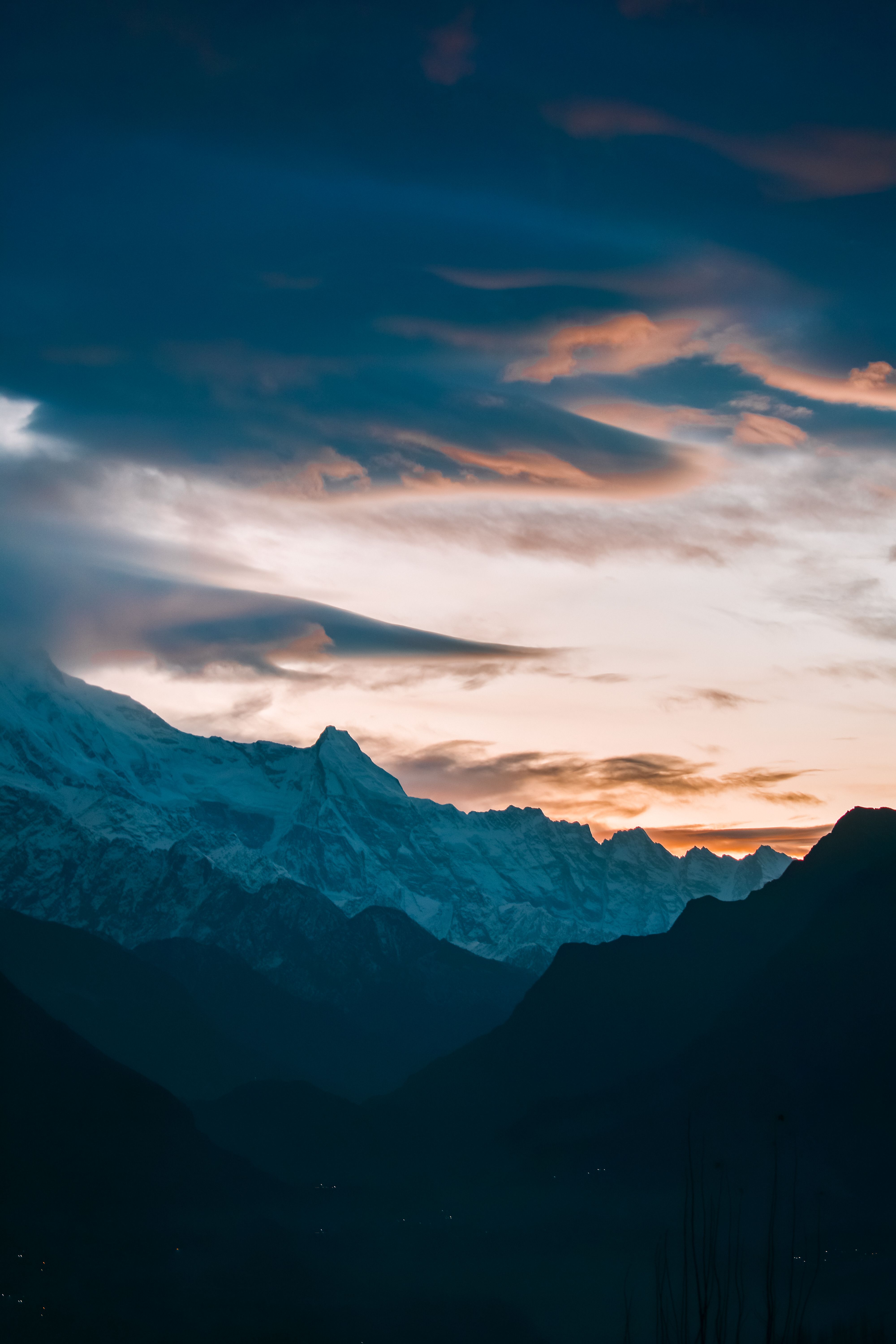 A sunset over the mountains with clouds and snow · Free Stock Photo