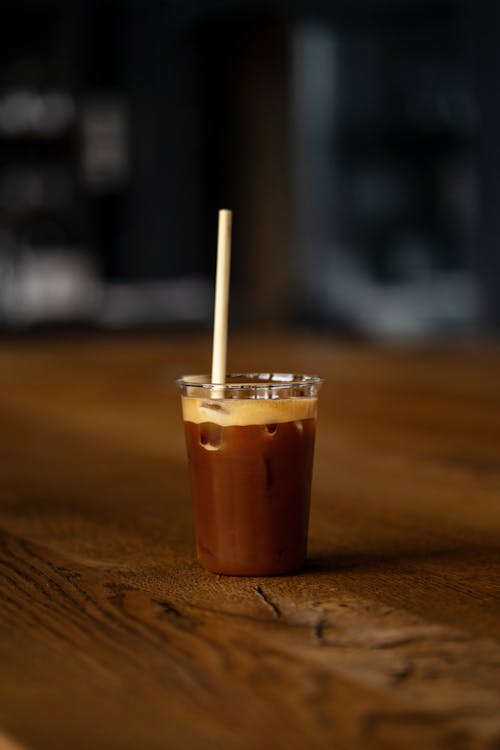 A cup of coffee with a straw on top