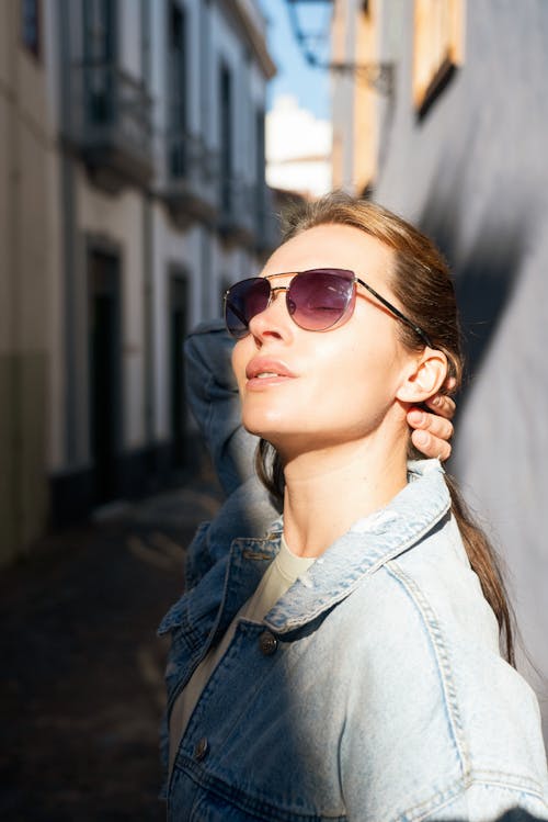 A woman in sunglasses leaning against a wall