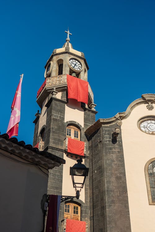 A clock tower with a red flag on top