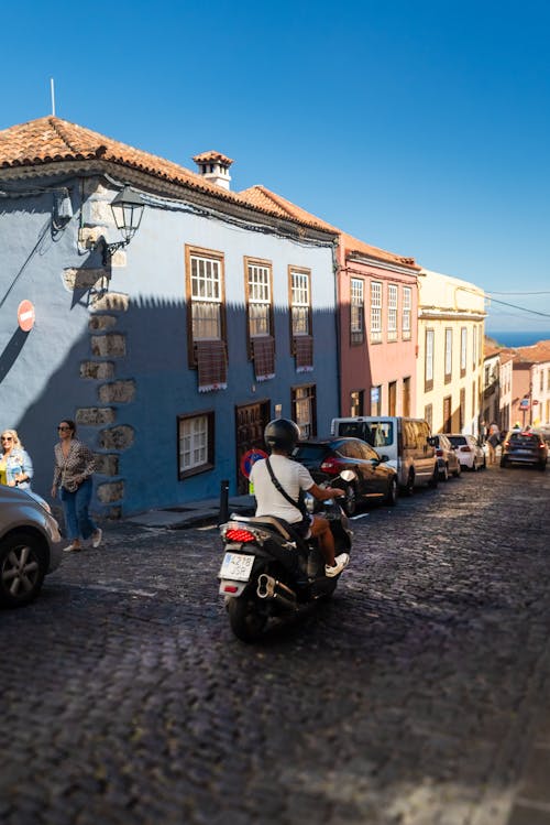 A person riding a motorcycle down a cobblestone street