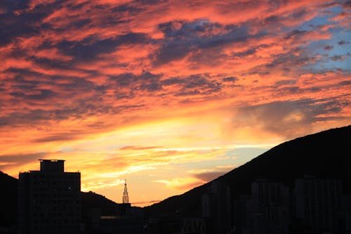 Силуэт городской пейзаж против драматического неба во время заката