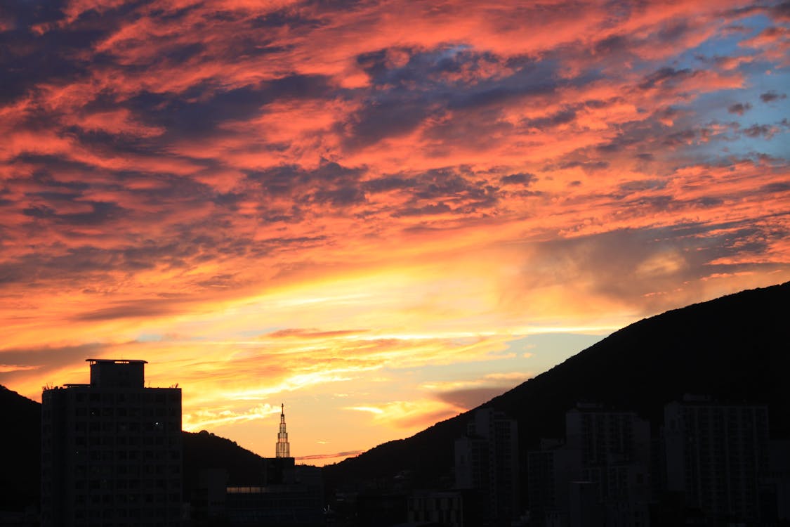 無料 日没時の劇的な空を背景にしたシルエットの街並み 写真素材