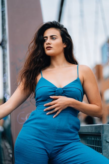 Young woman posing confidently in a blue jumpsuit outdoors in Chicago.