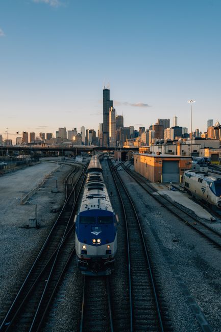 A train approaches the Chicago skyline at sunset, capturing the vibrant city's transport network.