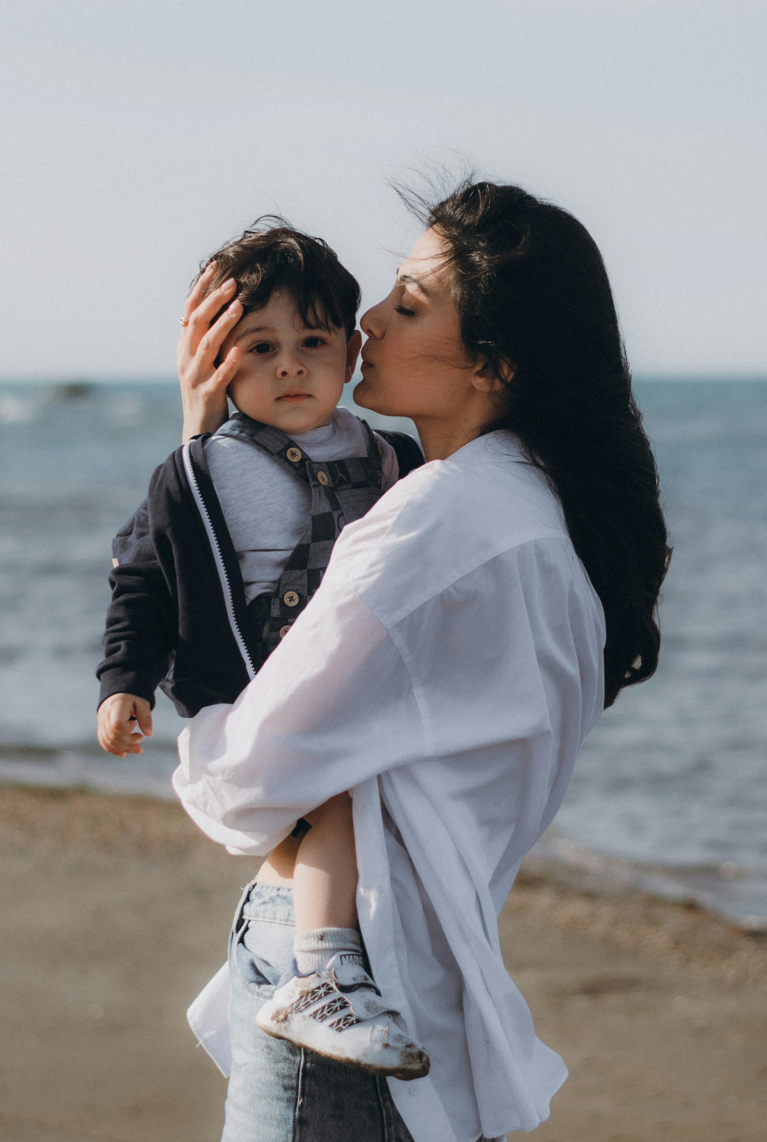 A touching portrait of a mother kissing her son on a beach in Baku, Azerbaijan.