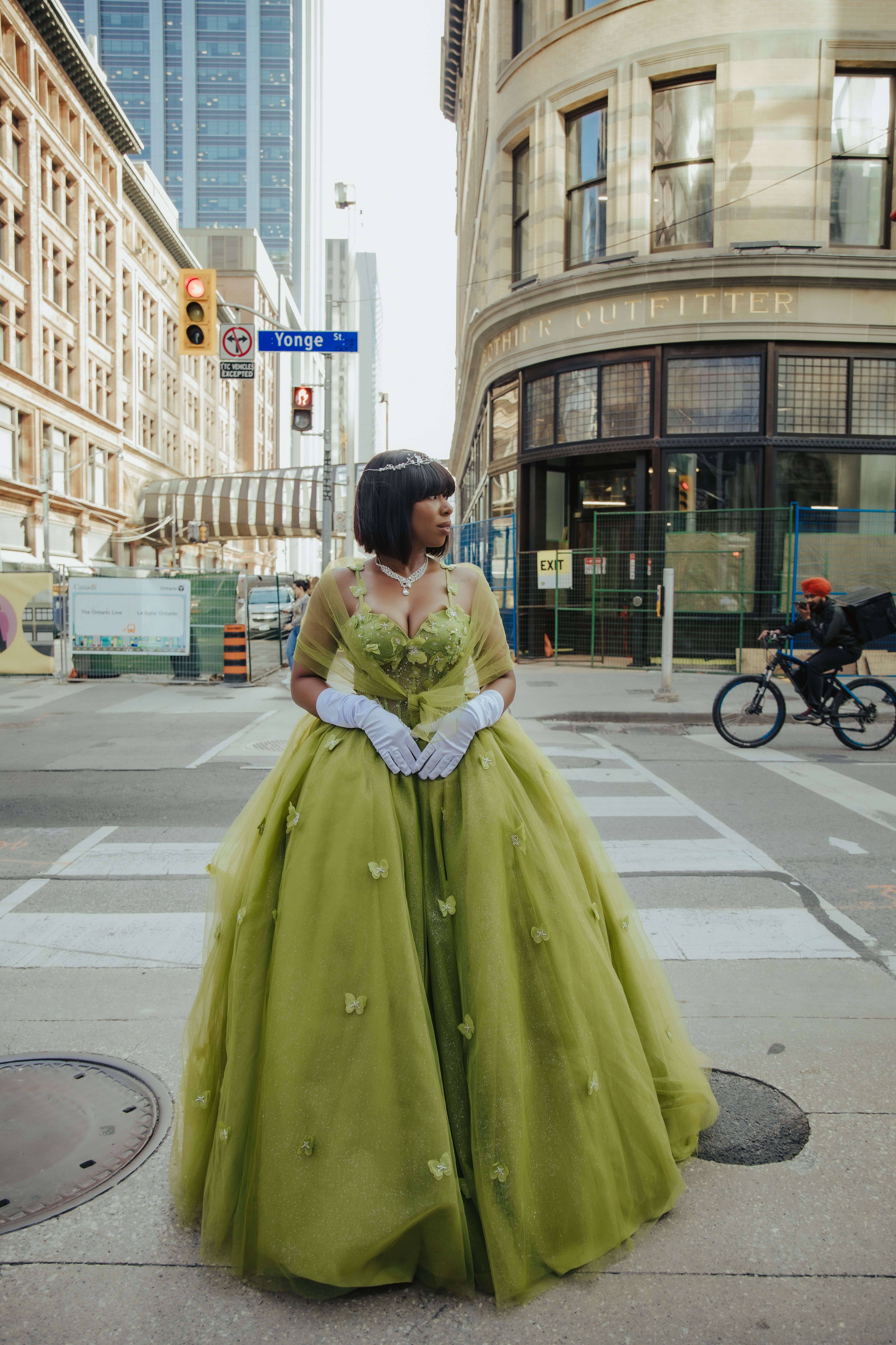A woman in a green dress standing on a street corner · Free Stock Photo