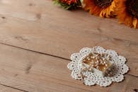 木桌上的蕾丝桌布缀有向日葵装饰的念珠，非常适合宗教主题