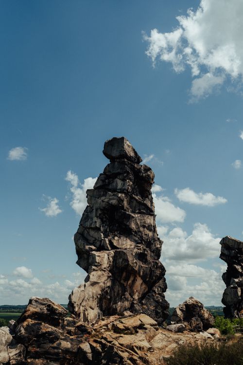Free Tall rock formation towers against a clear blue sky with scattered clouds, showcasing natural beauty. Stock Photo