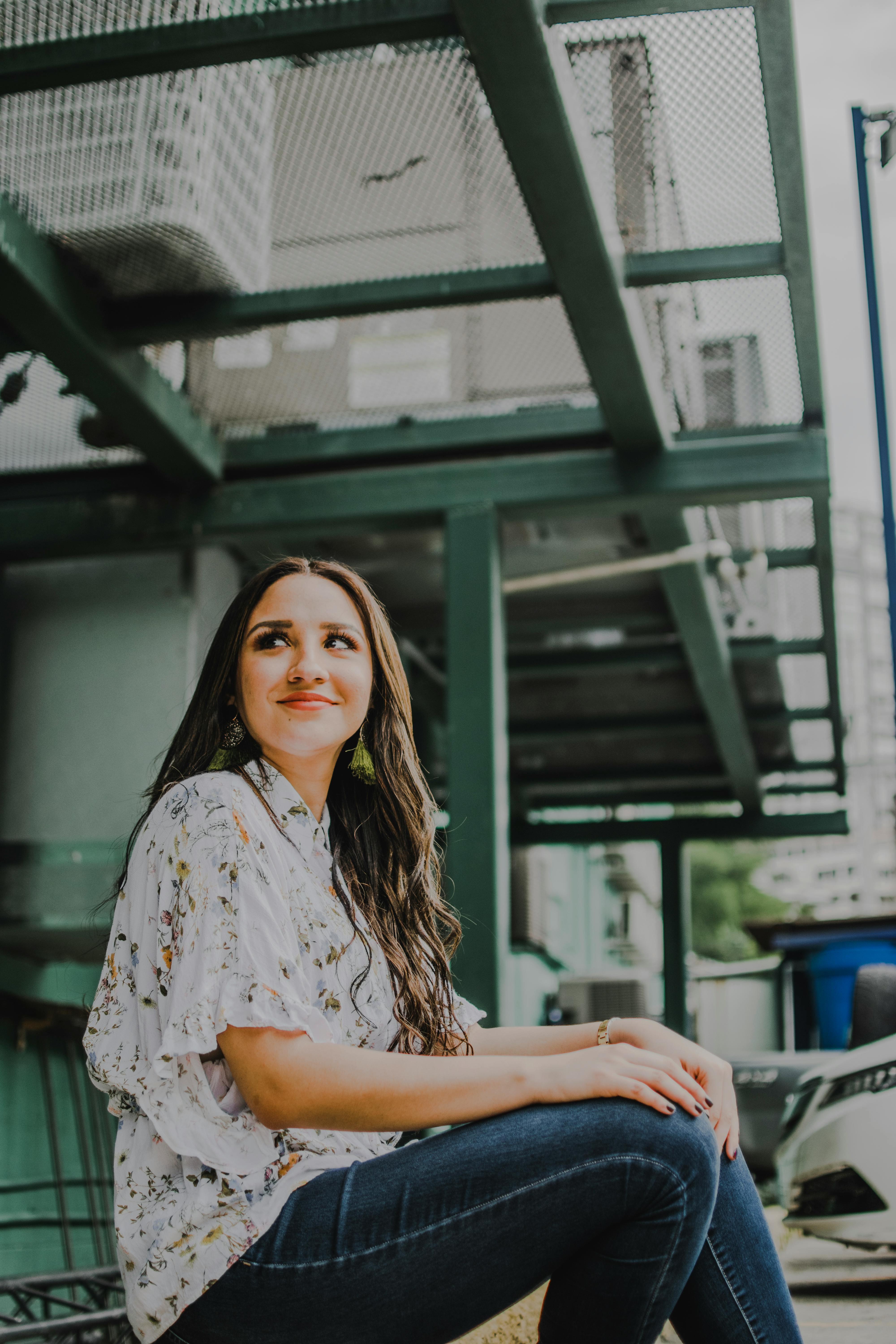 一位长发年轻女子在时尚都市中自信摆姿，散发着魅力与精致