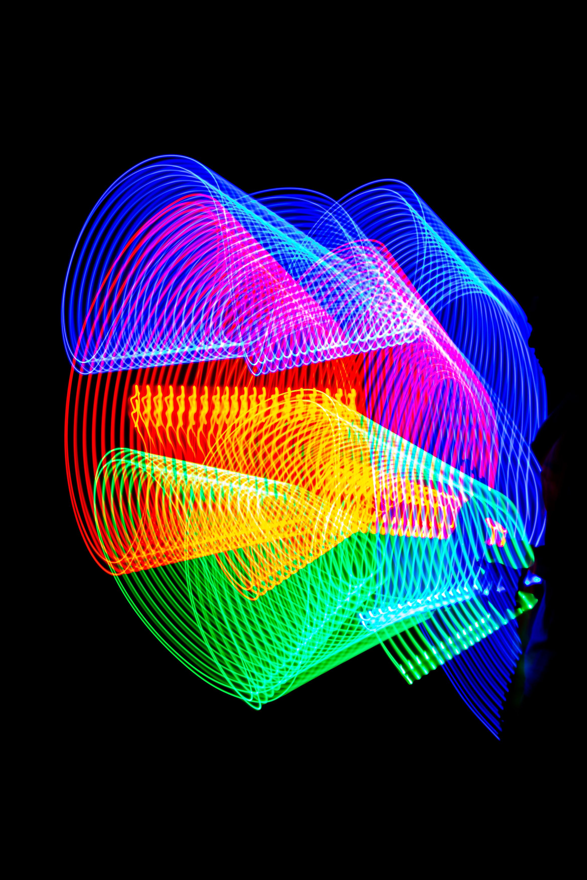 Vibrant abstract light patterns swirling on a dark background, showcasing dynamic neon colors.