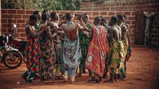 A vibrant cultural ceremony in Benin featuring a group in traditional clothing engaging in a ritual dance.
