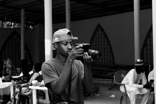 Monochrome Photo of Man Holding Dslr Camera