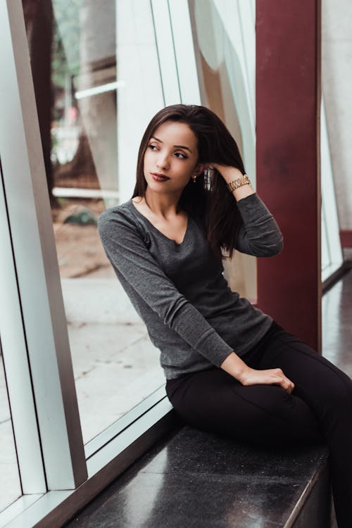 Woman Sitting Near Glass Window