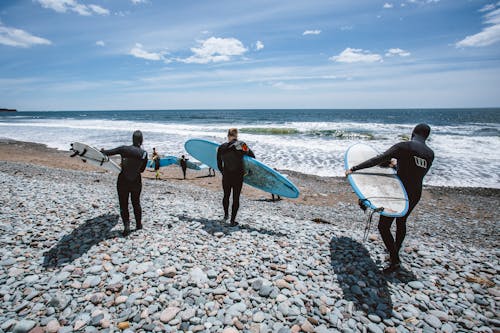 Pessoas Carregando Pranchas De Surfe Na Praia