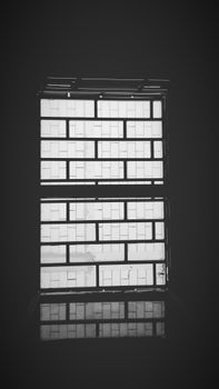 Minimalist black and white photo of a geometric window with reflection, creating a modern art feel.