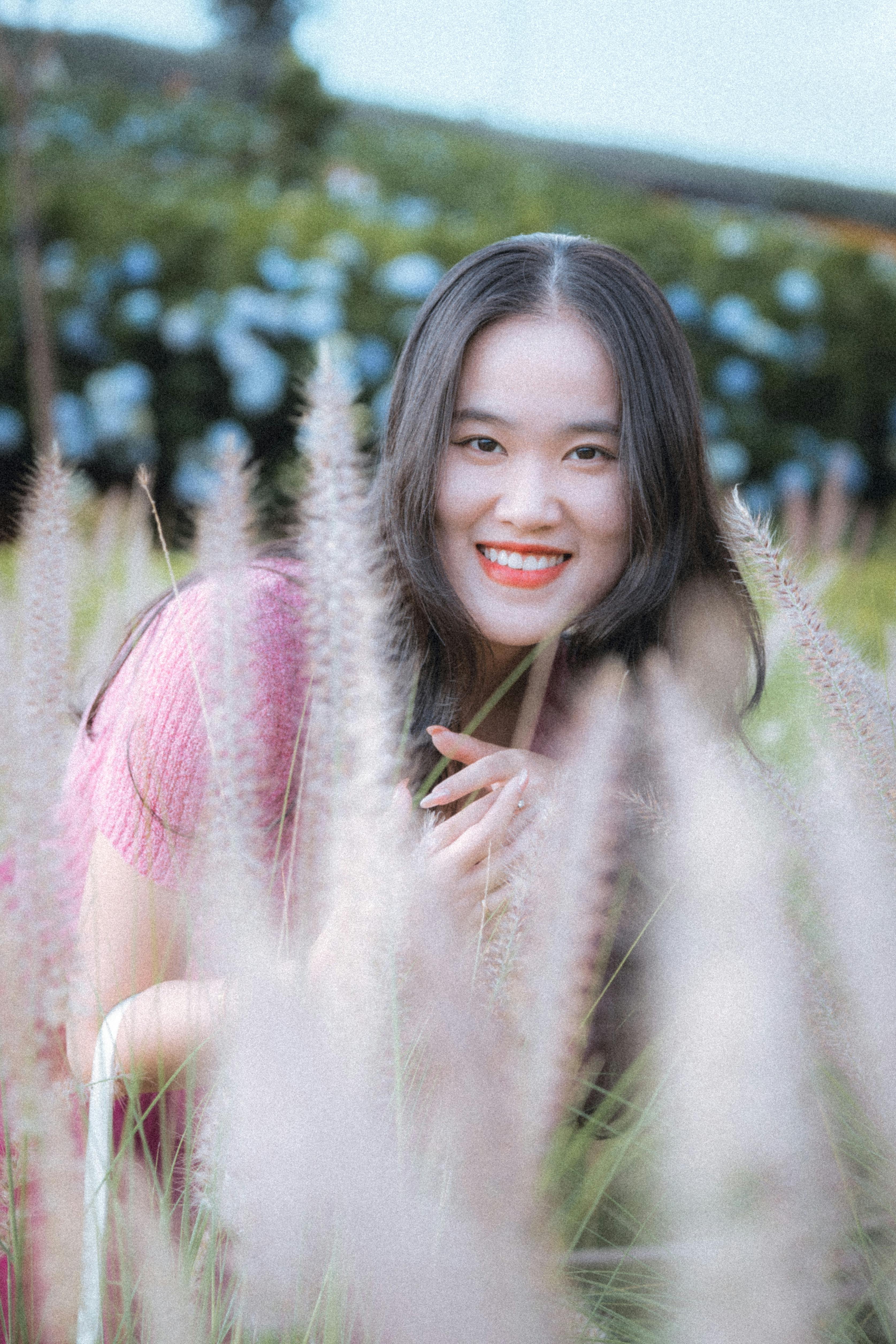 A cheerful woman enjoys a sunny day in a field in Dalat, Vietnam.