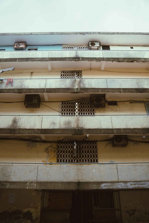 Free Aged urban apartment building showcasing decay and architectural layers in Ho Chi Minh City. Stock Photo