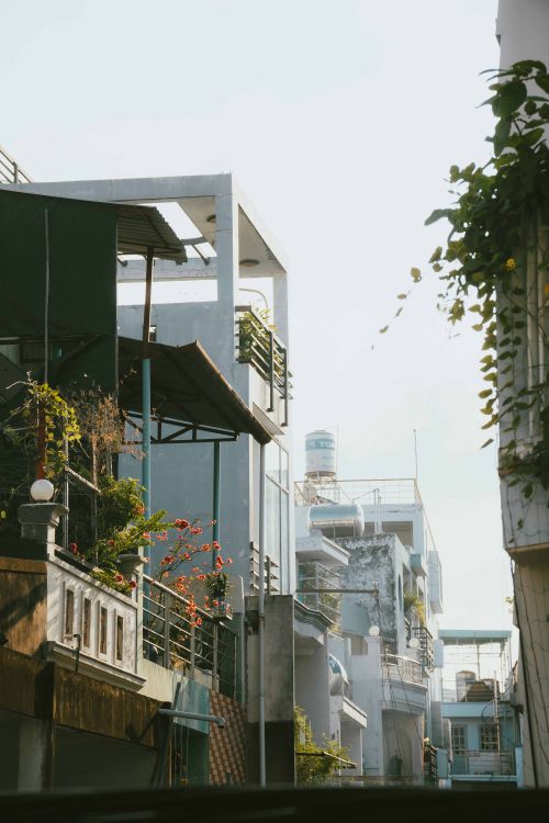 Free A narrow street in Ho Chi Minh City features modern balconies and lush plants. Stock Photo