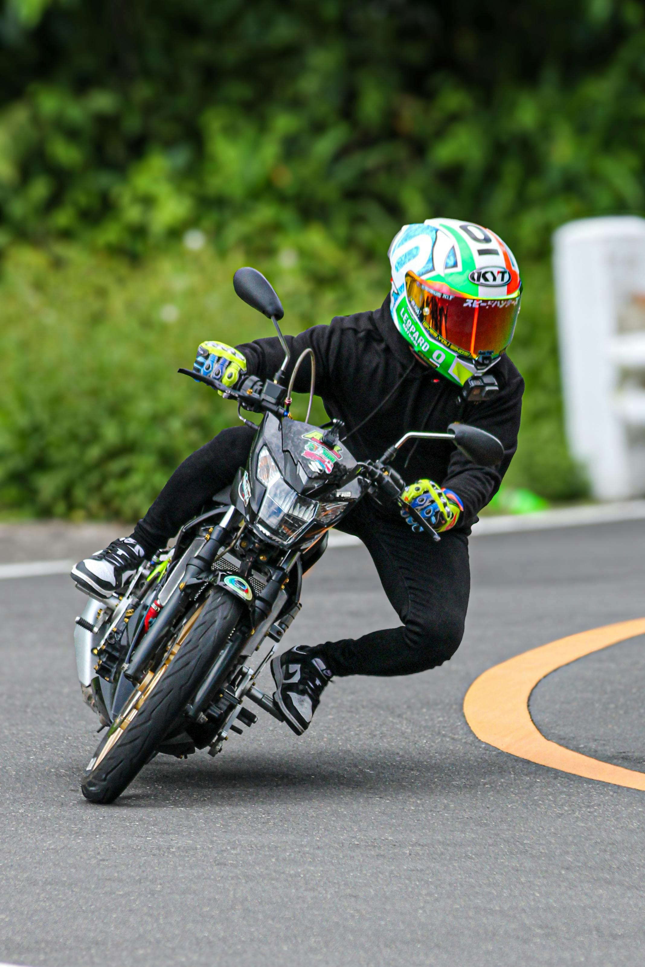 Action shot of motorcyclist leaning into a curve on a winding road.