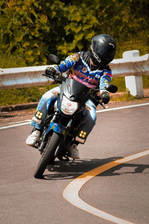 Free Rider on a motorcycle taking a sharp turn on a scenic outdoor road. Stock Photo