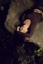 A woman laying on a rock in the water